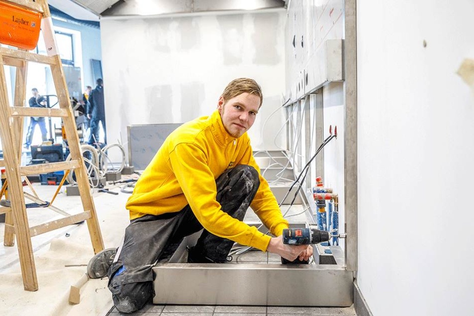 Monteur Manuel Thomke (22) arbeitet im Inneren an der Kochstrecke der Küche.