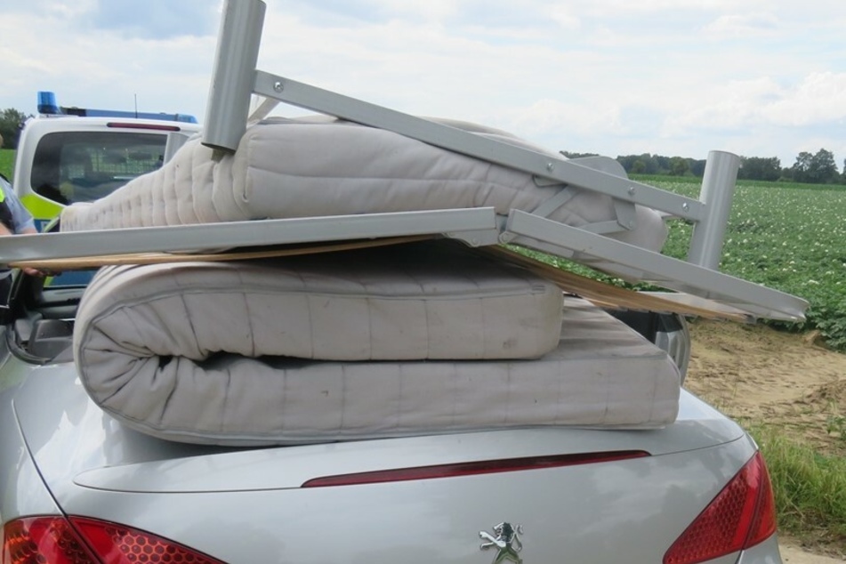 Der Fahrer (48) des Cabrios hatte ein Bettgestell und zwei Matratzen völlig ungesichert auf das Peugeot-Cabrio gelegt.