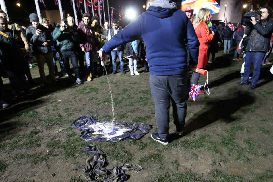 Ein Pro-Brexit-Anhänger gießt auf dem Parliament Square Bier auf eine EU-Flagge, bevor Großbritannien die Europäische Union verlässt.