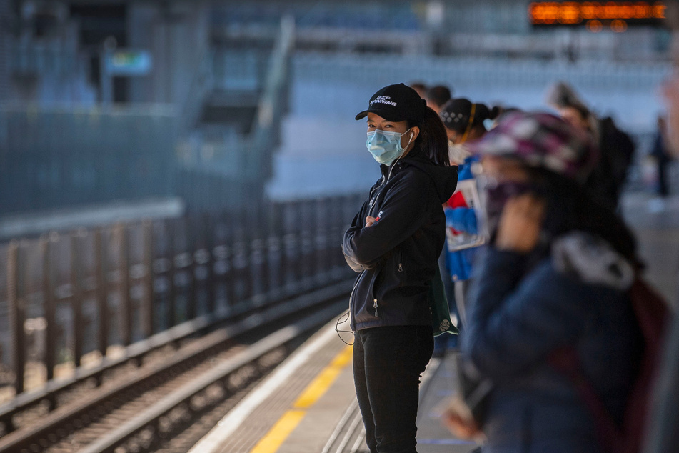 Fahrgäste stehen auseinander und tragen Gesichtsmasken auf einem Bahnsteig in der Londoner U-Bahn-Station. (Archivbild)