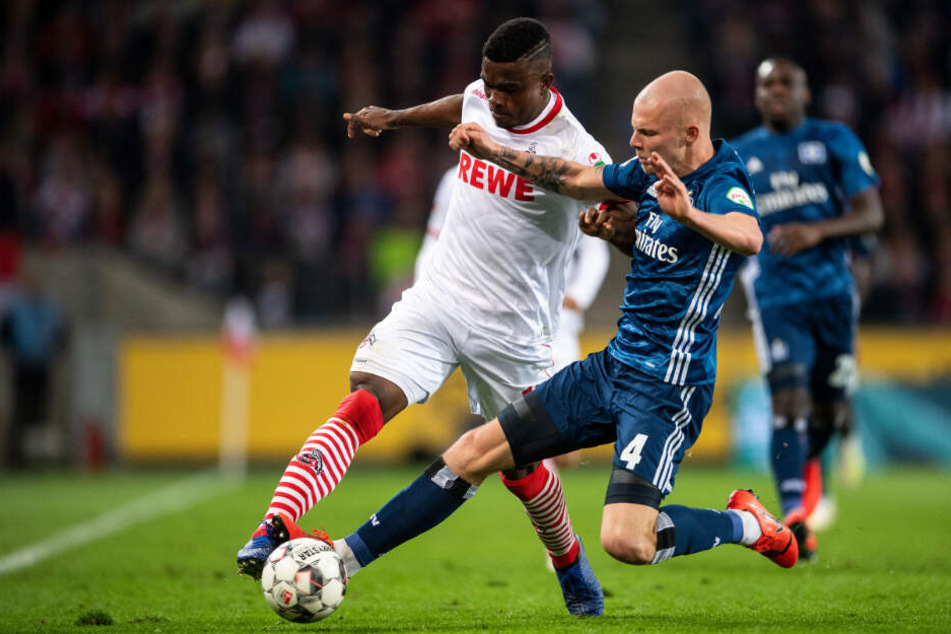 HSV-Kante Rick van Drongelen senst Kölns Stürmer Jhon Cordoba an der Seitenlinie um und bekommt dafür die gelbe Karte.