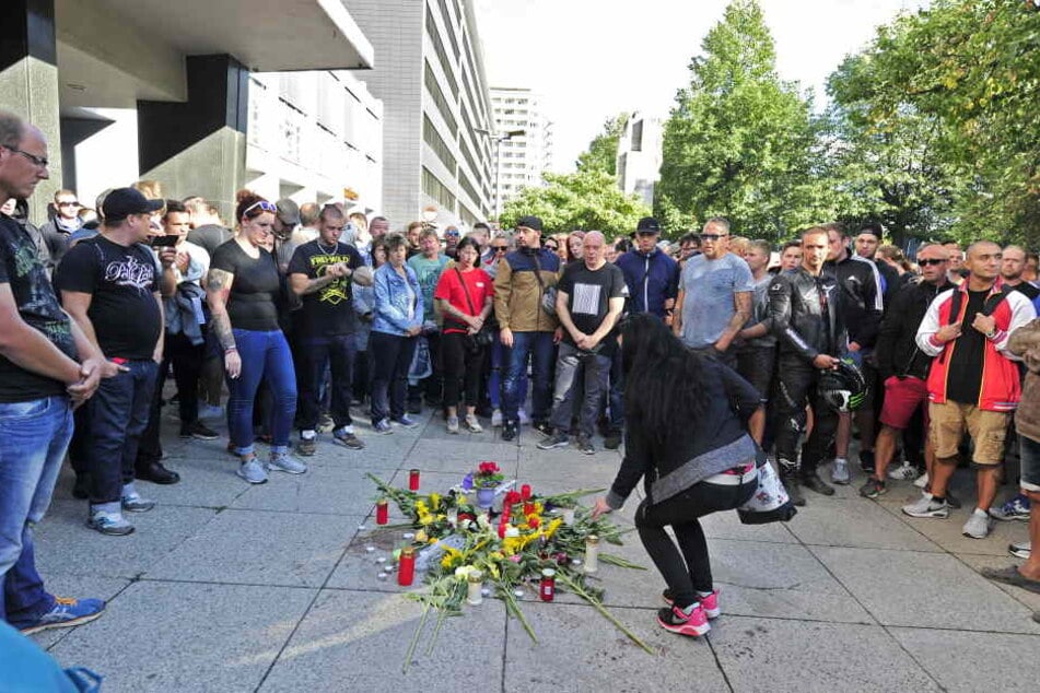 Am Tatort wurden Kerzen angezündet und Blumen niedergelegt: Viele Betroffene stehen im Kreis.