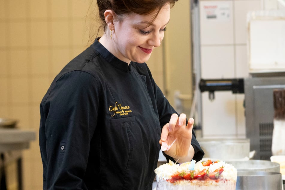 Handwerkskunst pur: Meister-Patissière Anna Theresa dekoriert eine Erdbeer-Sahne-Torte.