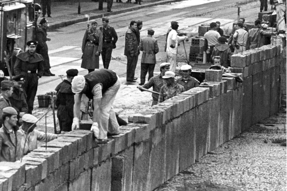 Unter der Aufsicht von bewaffneten Volkspolizisten errichtet eine Ostberliner Maurerkolonne am 18.8.1961 an der sowjetisch-amerikanischen Sektorengenze am Potsdamer Platz eine Mauer. (Archivbild)