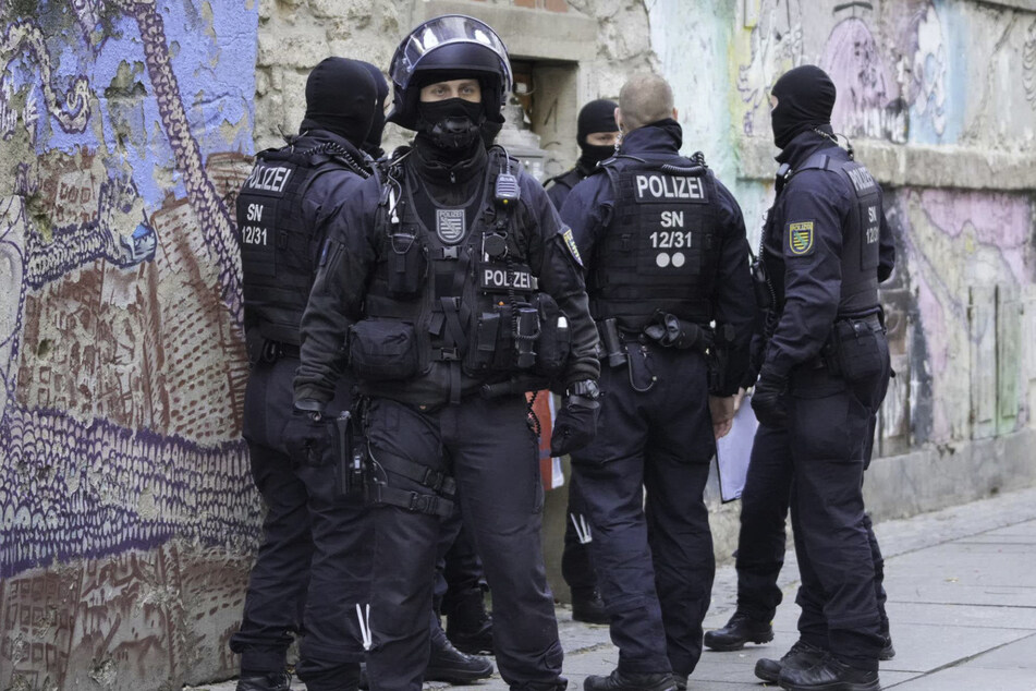 Maskierte Polizeibeamte durchsuchen am Mittwochmorgen eine Wohnung in der Dresdner Neustadt.