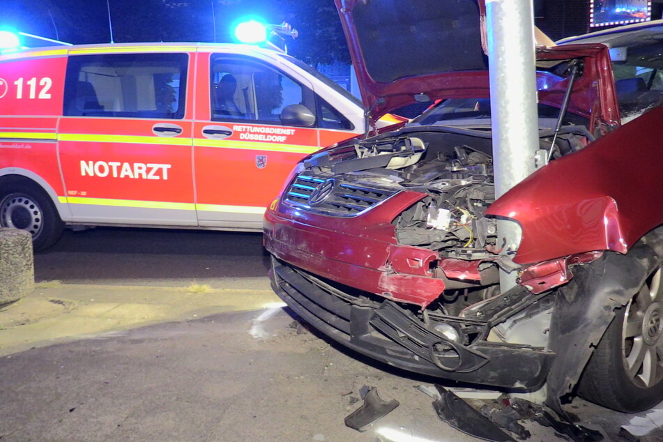 Der Unfallwagen ist mit der Motorhaube an einer Straßenlaterne stecken geblieben.