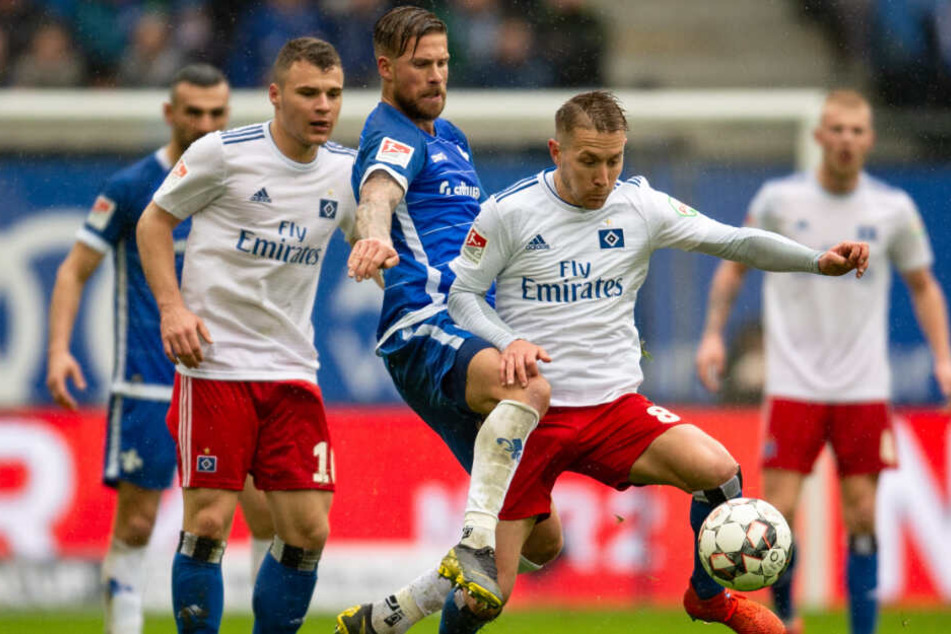 Lewis Holtby schirmt den Ball vor Tobias Kempe ab.