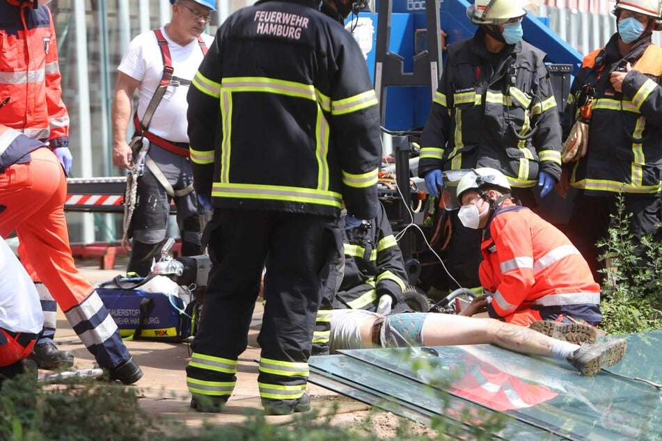 Die Rettungskräfte kümmern sich um den Mann, der von der Glasscheibe eingeklemmt wurde.