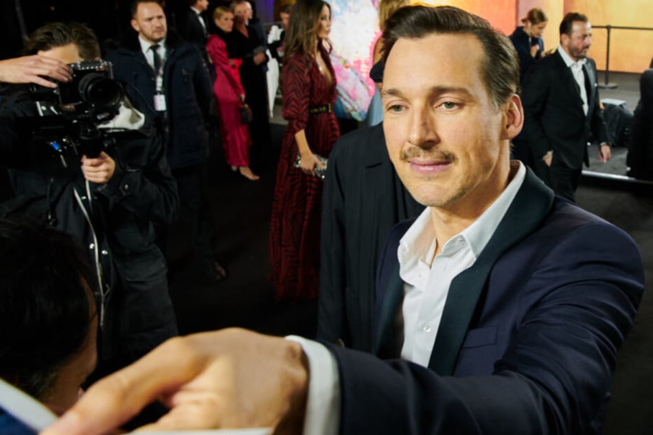 Florian David Fitz (44), Schauspieler, gibt Autogramme vor der Gala "Men of the Year" des Magazins GQ in Berlin.