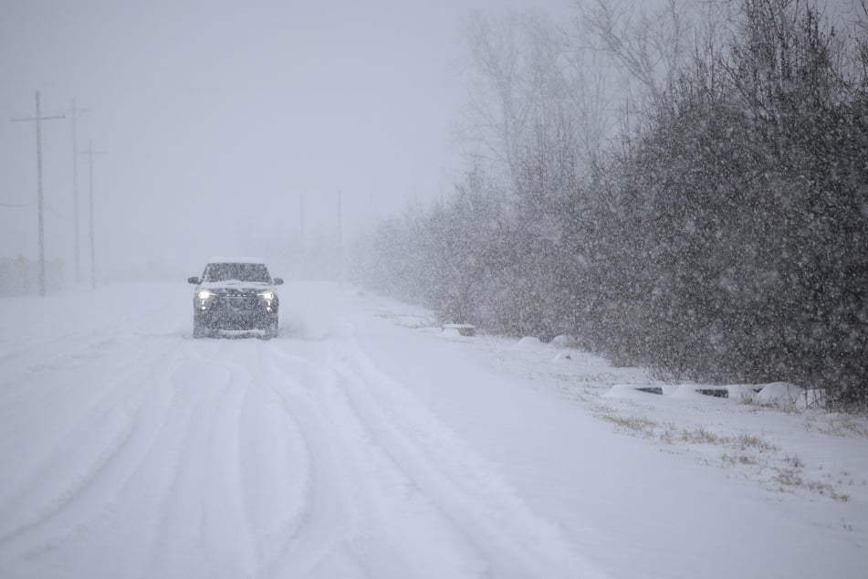 A motorist drives through the snow near Louisville Muhammad Ali International Airport on Sunday in Louisville, Kentucky. Local forecasts called for heavy snowfall followed by significant accumulation of freezing rain and ice.