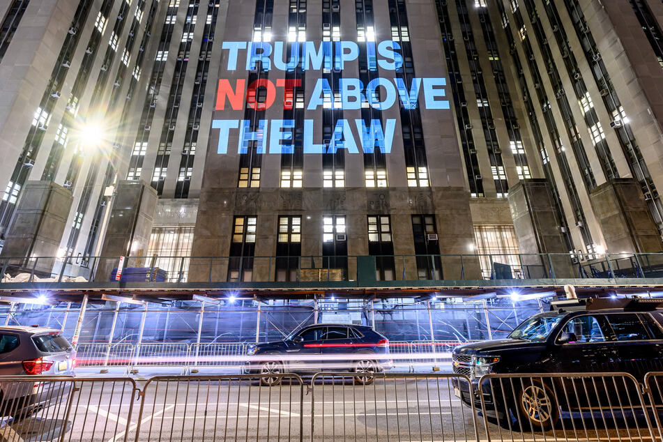 A projection that reads "Trump is Not Above the Law" is illuminated on the Manhattan Criminal Court on Sunday in New York City.
