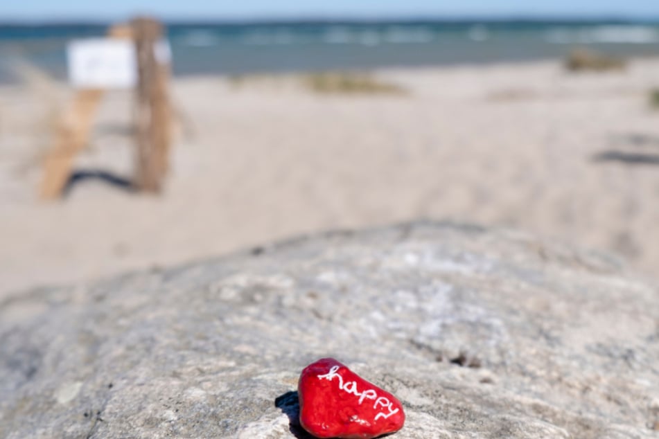 Auf dem Stein steht happy. Das dürfte in den nächsten Wochen aber niemand sein, der Urlaub machen will...