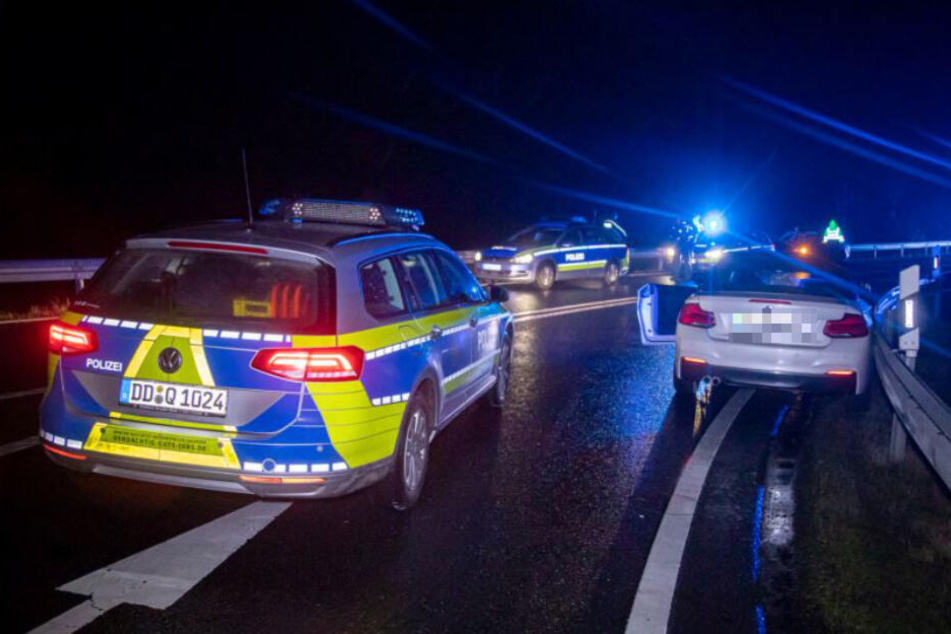 Drei Streifenwagen der Polizei stehen um den gestohlenen BMW.
