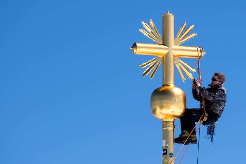 Schlosser Johannes Wagner repariert das Gipfelkreuz auf der Zugspitze.