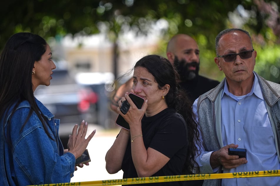 Menschen stehen hinter dem Polizeiband am Tatort nach Schüssen vor dem Islamic Center of San Diego.