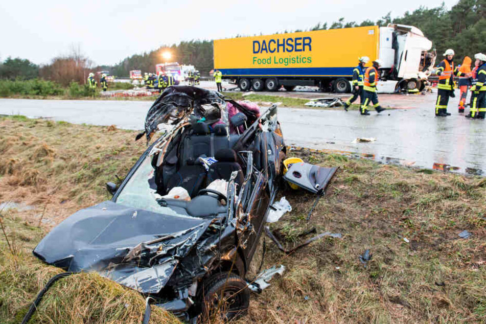 Ein Autowrack liegt neben der Autobahn auf dem Grünstreifen, nach dem es bei dem Unfall mit mehreren Fahrzeugen und einem Viehtransporter komplett zerstört wurde.