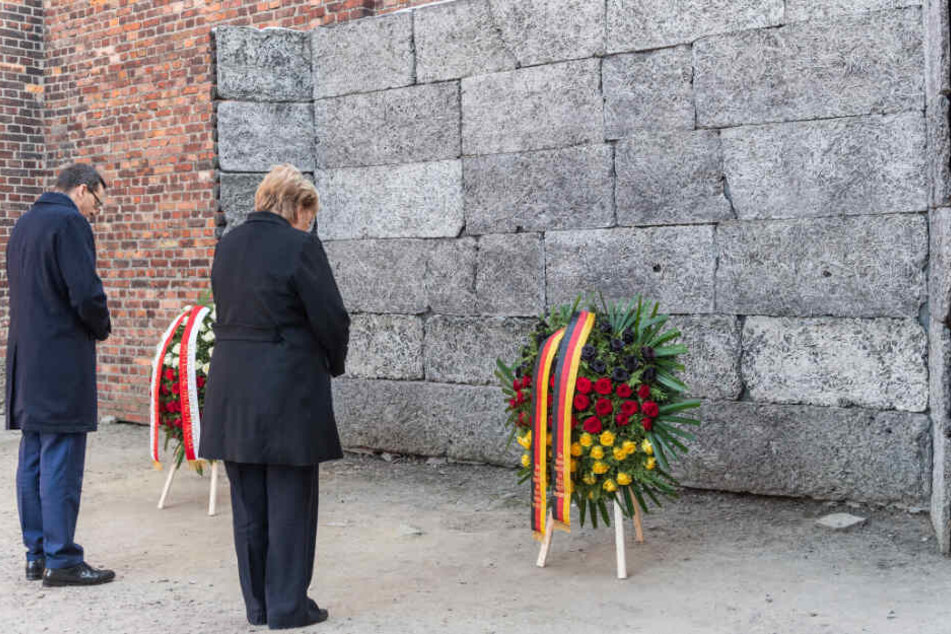 Bundeskanzlerin Angela Merkel (CDU) und Mateusz Morawiecki, Ministerpräsident von Polen, stehen bei einer Kranzniederlegung an der Todesmauer im ehemaligen deutschen Konzentrationslager Auschwitz.
