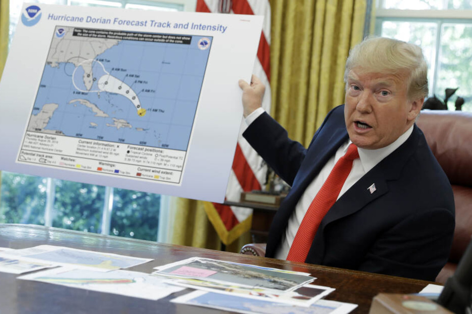 Donald Trump (73) hält ein Plakat, das den Verlauf des Hurrikans "Dorian" veranschaulicht, während er im Oval Office des Weißen Hauses mit Journalisten spricht.