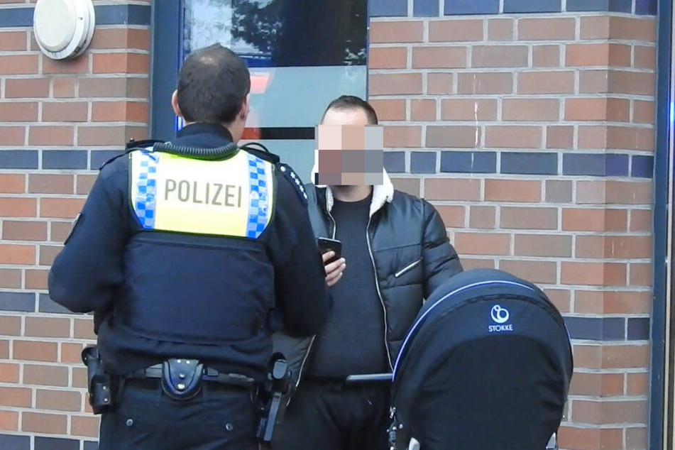 Ein Polizist ermahnt einen Mann, der mit seinem Handy Aufnahmen vor Ort machte.