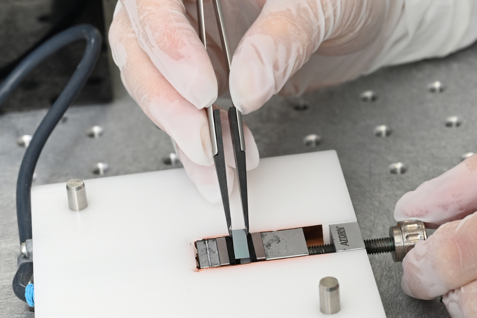 Stuttgart: In einem Labor der Firma Q.ANT wird von einer Ingenieurin ein neu entwickelter Chip zum Einsatz in einen Quantencomputer in eine Kontrollvorrichtung eingelegt.