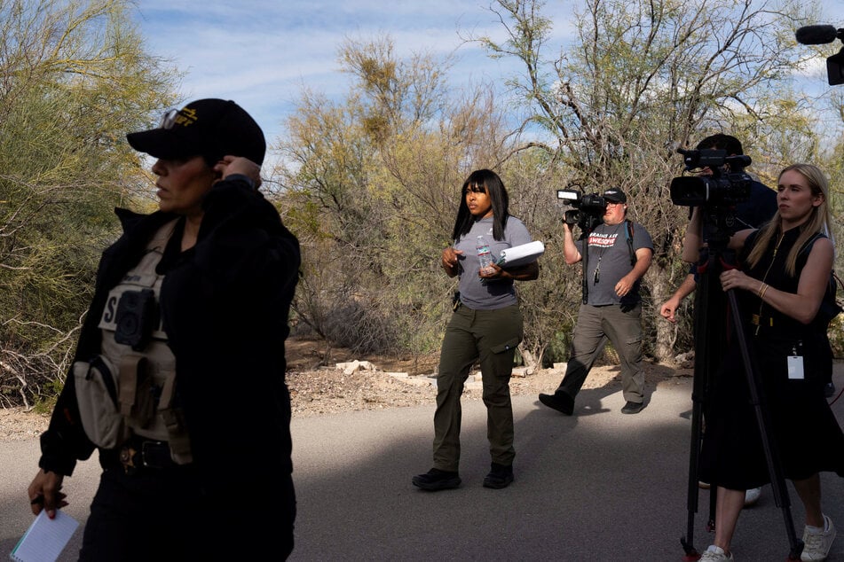 Investigators canvass Annie Guthrie's neighborhood, accompanied by members of the media, after the disappearance of Nancy Guthrie on February 10, 2026.