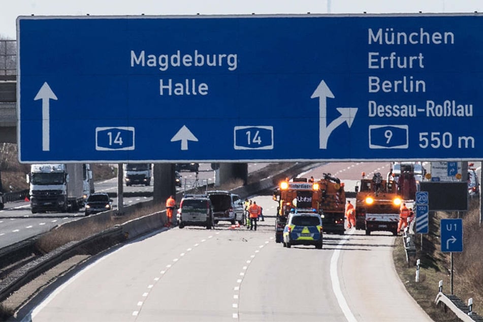 Voll gesperrt: Einsatzkräfte beseitigen die Trümmerteile, die sich bei dem Unfall auf der kompletten Fahrbahn verteilt hatten.