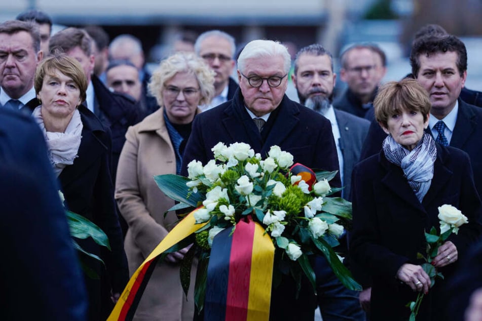 Frank-Walter Steinmeier (M), Bundespräsident, hält während einer Gedenkveranstaltung einen Strauß Blumen und steht neben seiner Frau Elke Büdenbender (2.v.l) und Ursula Bouffier (2.v.r).