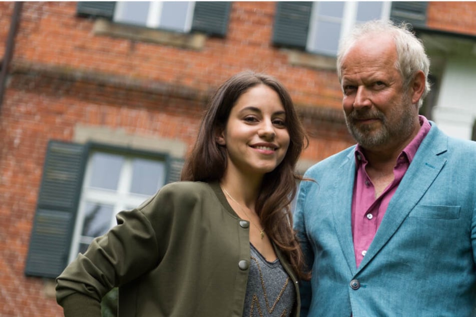 Die Schauspieler Almila Bagriacik (links) und Axel Milberg stehen vor einem der Drehorte für den aktuellen Tatort im schleswig-holsteinischen Niendorf.