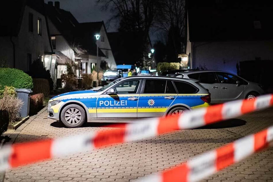 Absperrband der Polizei hängt während eines Polizeieinsatzes vor dem Abschnitt der Straße, in dem das Gewaltverbrechen passierte.