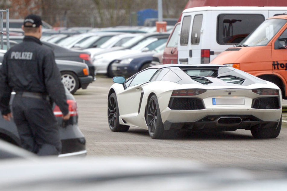 Ein Polizeibeamter blickt auf einen fahrenden Lamborghini. (Symbolbild)