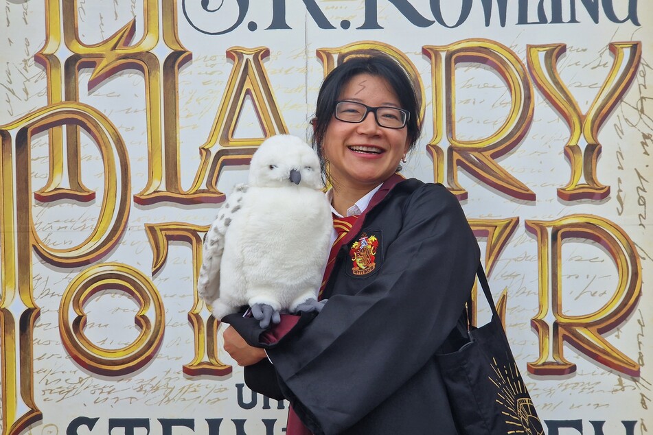 Yan mit Plüsch-Eule Hedwig vor dem Cover der Erstausgabe von "Harry Potter und der Stein der Weisen".