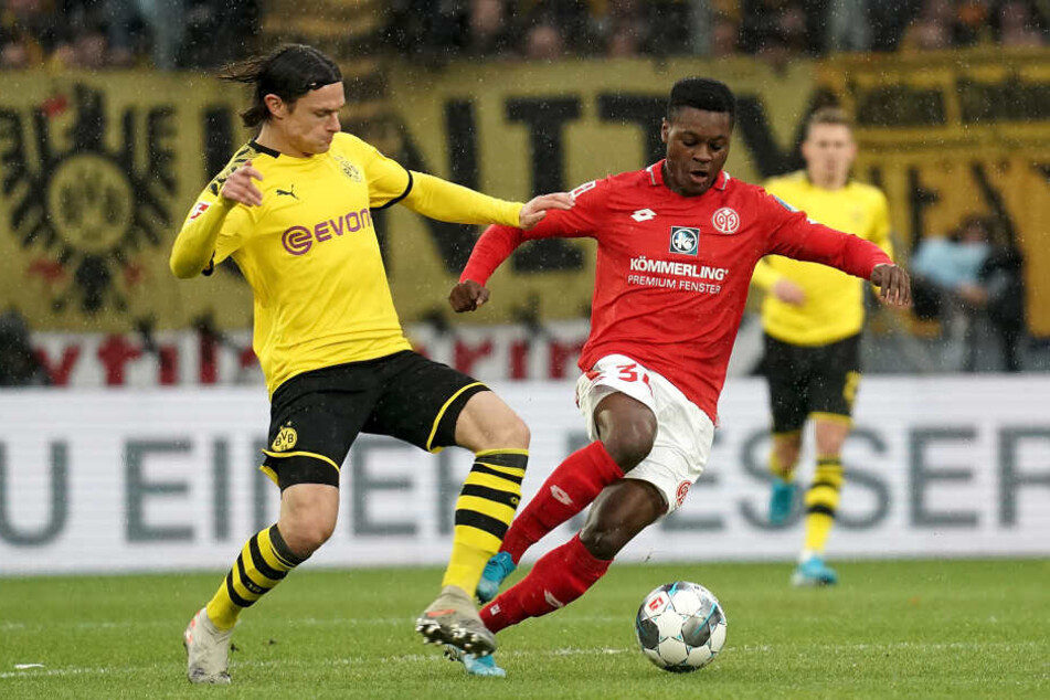 Der Mainzer Ridle Baku (r) neben Nico Schulz (l) aus Dortmund am Ball.