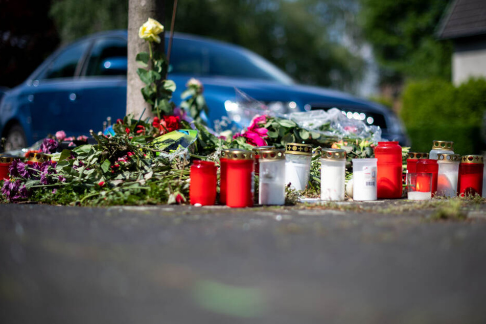 Blumen und Kerzen stehen in Moers an der Stelle, an der eine unbeteiligte Frau bei einem mutmaßlichen Autorennen verletzt und später gestorben ist.