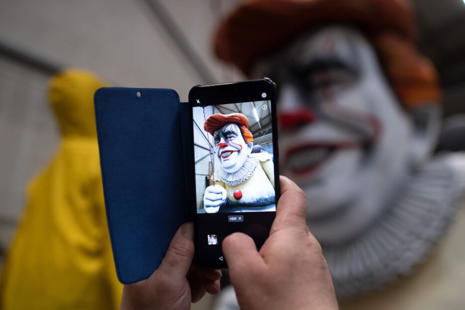 Ein Besucher fotografiert den Karnevalswagen mit dem amerikanischen Präsidenten Donald Trump als Horrorclown "Penny Wise" aus dem Film "Es".