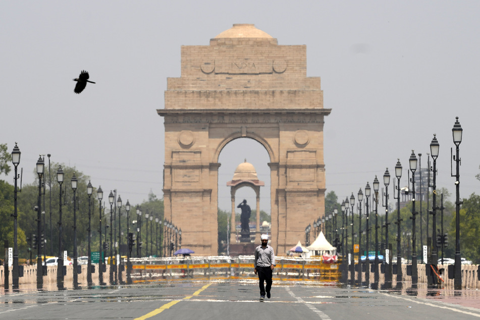 Bei sengender Hitze geht ein Mann in Neu-Delhi am India Gate Monument vorbei.