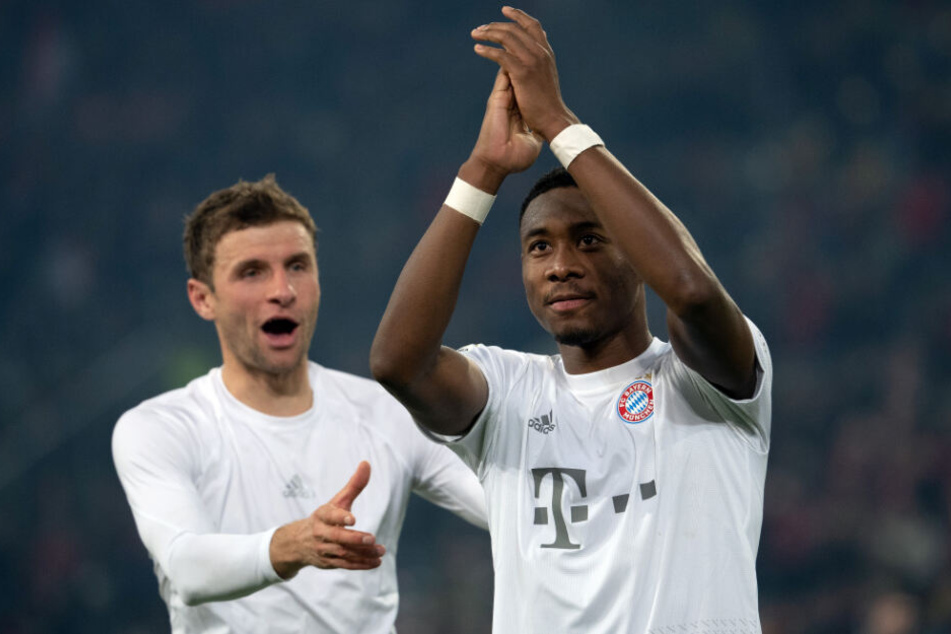 Thomas Müller (l) und David Alaba feiern nach einem Sieg des FC Bayern.