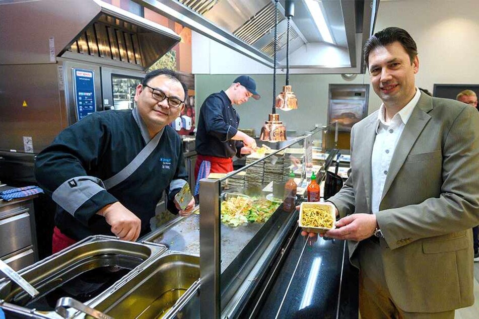 Mensaleiter André Müller (50, r.) bedient sich zur Eröffnung der neuen Mensa auf dem TU-Campus im Frontcooking-Bereich bei Koch Xiao Wang.