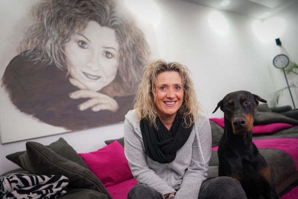 Daniela Alfinito zusammen mit ihrem Dobermann Falcon im heimischen Wohnzimmer.