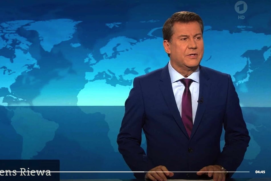Sprecher Jens Riewa schaut verdutzt in die Kamera und wendet sich an die Regie.