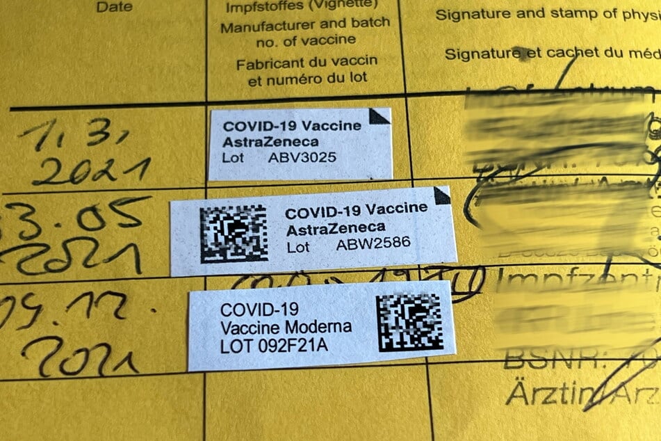 Aufkleber, Datum und Stempel dokumentieren Corona-Impfungen im gelben Impfpass.