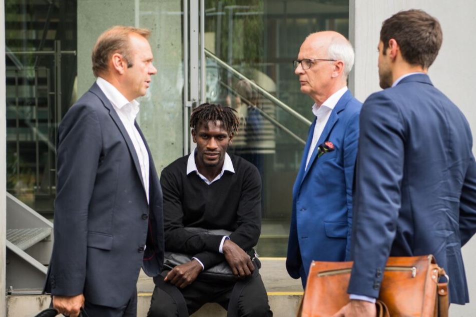 Bakery Jatta (Hamburger SV, 2.v.l.) sitzt neben Bernd Hoffmann (l), Vorstandsvorsitzender des HSV, auf dem DFB-Gelände auf einer Mauer.