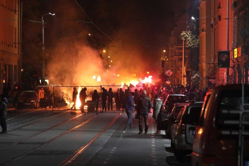 In der Wolfgang-Heinze-Straße stehen sich zündelnde Protestierende und Polizisten gegenüber.