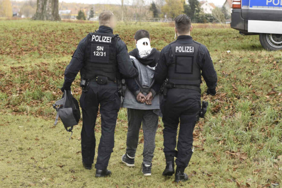 Nachdem dem Mann eine Halskrause angelegt wurde, wird er von Polizisten abgeführt.