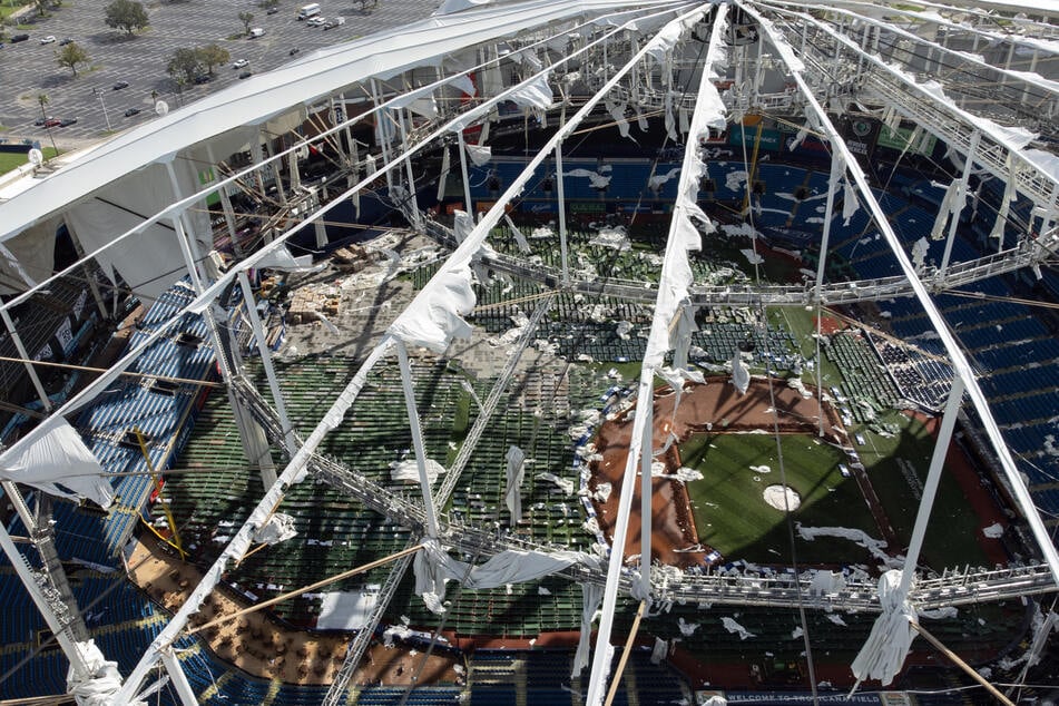 Wind uprooted large trees and ripped apart the roof at the Tampa Bay Rays' Tropicana Field baseball stadium in St. Petersburg and sent a construction crane falling onto a downtown building nearby.