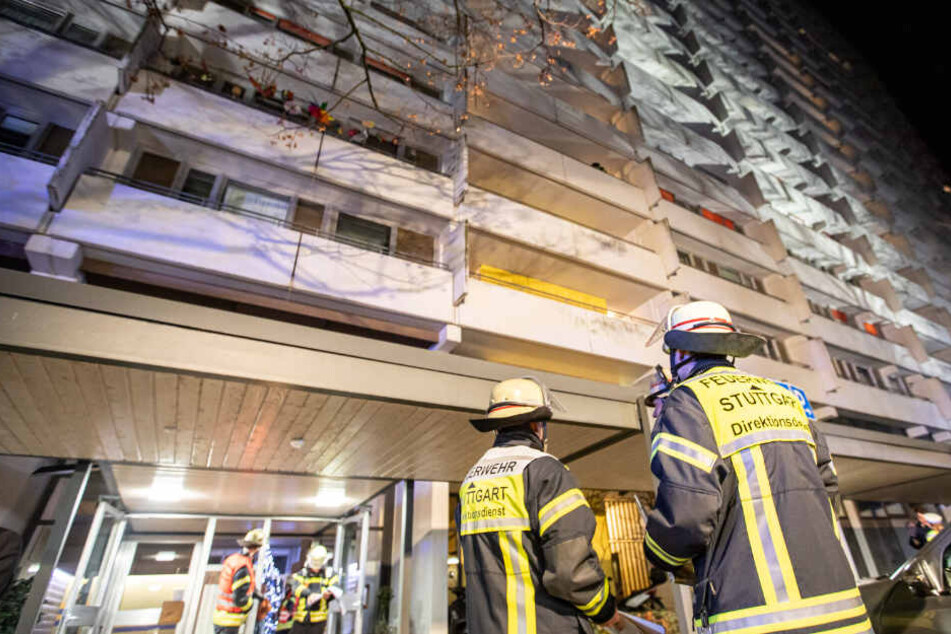Feuerwehrmänner stehen vor dem Wohngebäude.