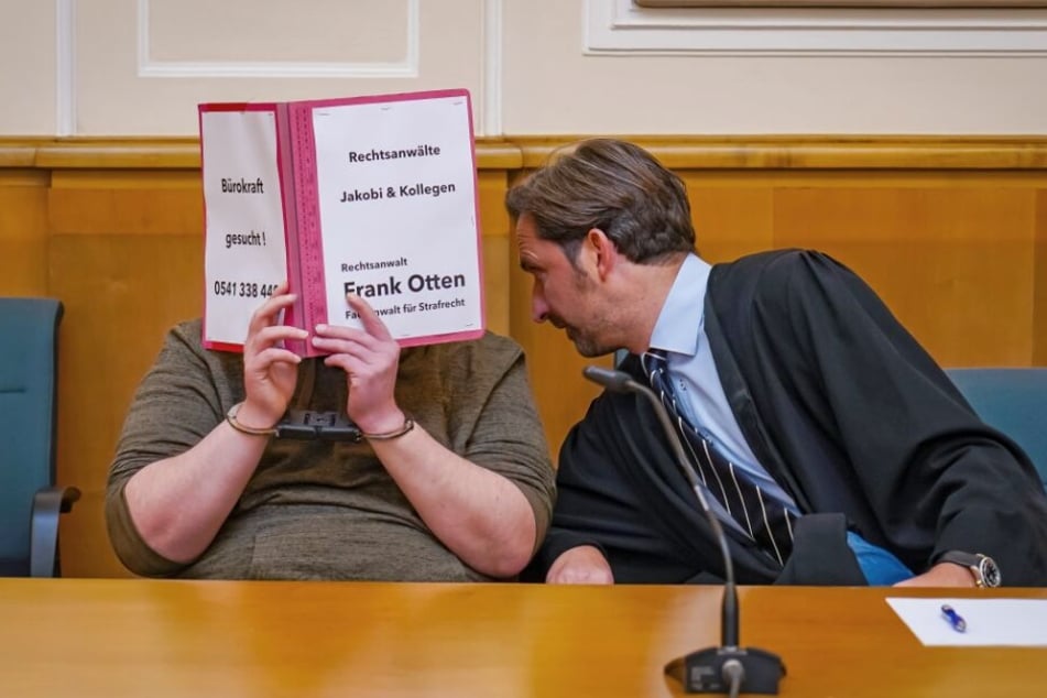 Der Rechtsanwalt Frank Otten (r) beugt sich zu dem 32-jährigen Angeklagten.