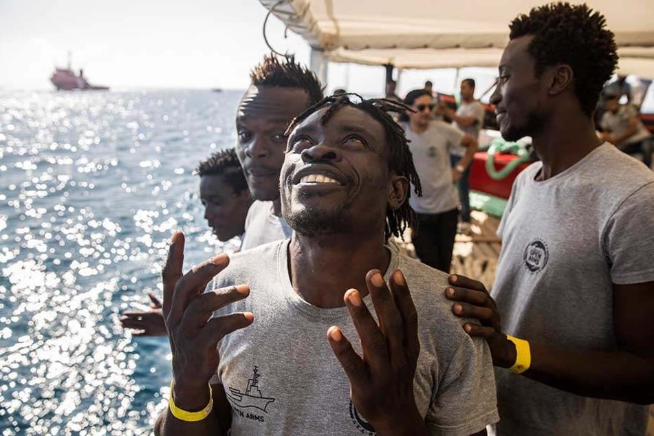 Migranten an Bord des Rettungsschiffs der spanischen Nichtregierungsorganisation Proactiva Open Arms freuen sich über ihre Ankunft in Barcelona.