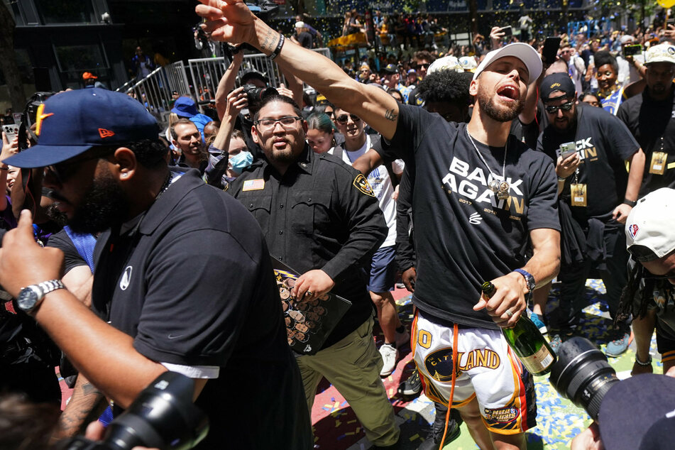 Steph Curry leads the celebrations on the streets of San Francisco.