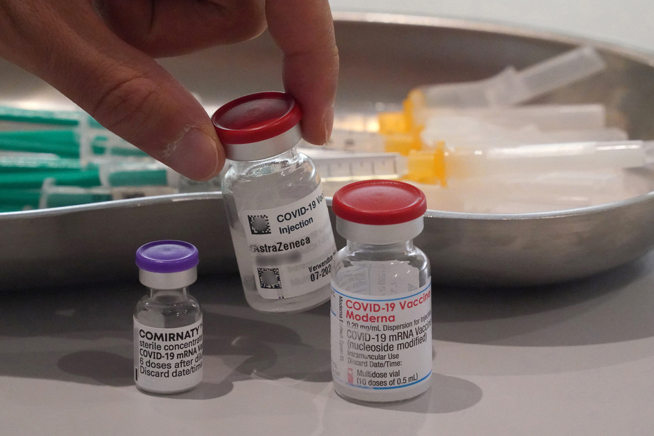 Ein Mitarbeiter nimmt eine Impfdose Astrazeneca vom Tisch. In Bremen sinkt die Nachfrage nach Impfterminen.