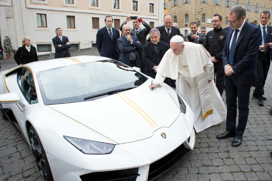 Der Papst signiert für den guten Zweck.